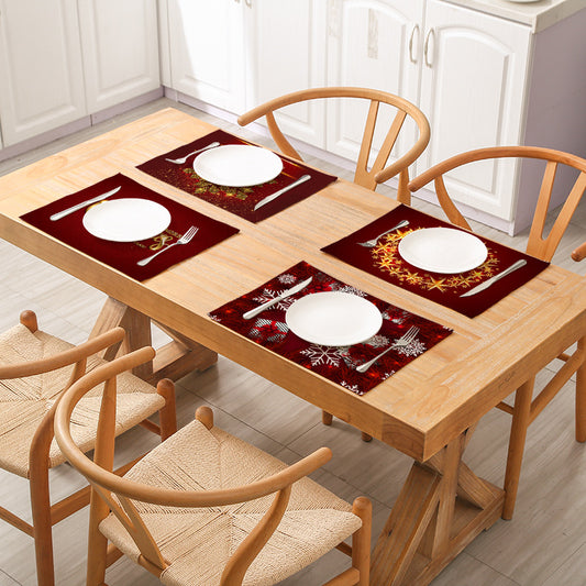 Dining table set with plates, cutlery, and placemats on a wooden table with chairs.