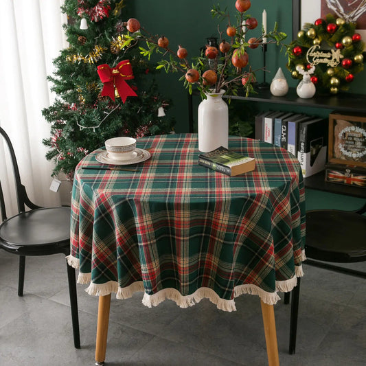 Round table with a green plaid tablecloth in a room decorated for Christmas.