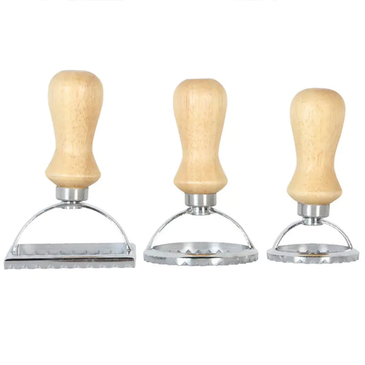 Three metal stampers with wooden handles on a white background