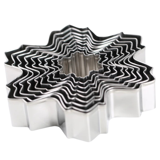 Set of metal cookie cutters with wavy edge design on a white background